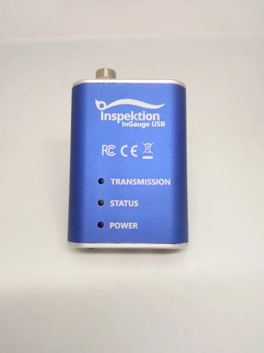ด้านหน้า InGauge USB สีน้ำเงิน มีโลโก้ เครื่องหมาย FCC และ CE และไฟสถานะ TRANSMISSION STATUS POWER